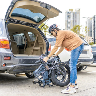 Man Storing a Foldable E-Bike in his Car 